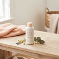 Little Bloom Baby Care Poudre de Talc small travel size white bottle with cream cap surrounded by chamomile and lavender on wooden table